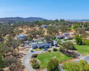 Cal King Pest Control   Cal King Pest Control   Aerial view of a small suburban neighborhood with single family homes a curved gravel road and scattered trees in a dry landscape